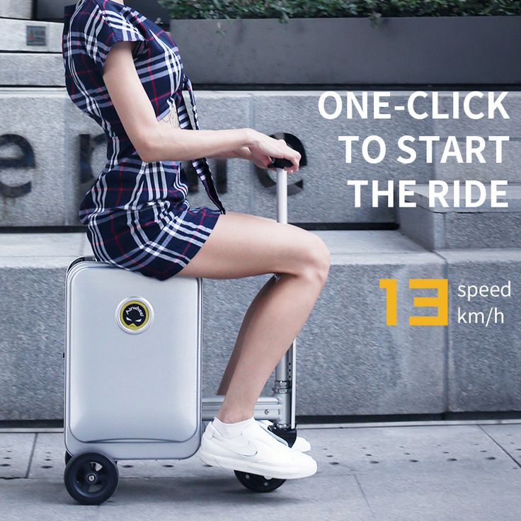 A person riding an Airwheel SE3S smart suitcase. The suitcase is silver with an integrated handlebar and wheels. The person is dressed in a checkered outfit and white sneakers. The text overlay reads, 'ONE-CLICK TO START THE RIDE' and '13 speed km/h.