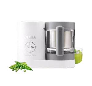 Beaba Babycook Neo all-in-one baby food maker in white and grey, shown with fresh green peas ready for steaming—ideal for nutrient-rich first foods and smooth purees.