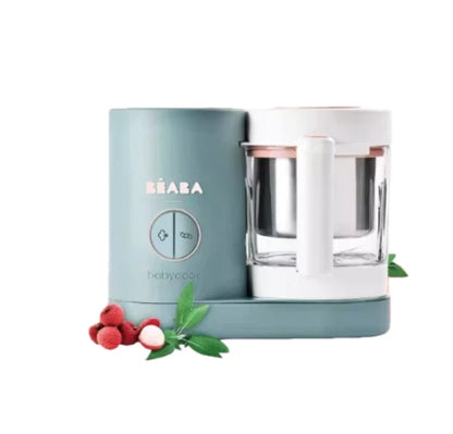 Beaba Babycook Neo baby food maker in mint green, displayed with lychee fruit and leaves—compact, stylish, and perfect for making tropical fruit purees safely at home.