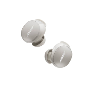  A pair of Bose QuietComfort Earbuds in a light Stone color, shown on a clean white background to highlight their minimalist and compact design.