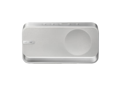 A top-down view of the Bose SoundLink Home Bluetooth Speaker in a clean, silver finish, showcasing its minimalist design, textured speaker grille, and simple control buttons.