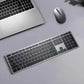 Top-down view of the Dell KM7321W wireless keyboard and mouse placed next to a silver laptop on a gray desk. The sleek design complements modern workspaces, offering seamless wireless connectivity and quiet operation for daily computing tasks.