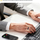 Close-up of a businessman’s hand wearing the black Dreame Ring while typing; smartphone displays an incoming call, illustrating haptic alerts for calls, messages, and wellness reminders.