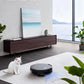 The sleek, black ECOVACS Deebot X8 Pro Omni cleaning a rug in a modern living room while a white cat sits nearby. This image highlights the vacuum's hair tangle-free design, making it essential for pet-owning families.