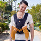 Father wearing Ergobaby Aerloom baby carrier in navy, carrying toddler in front-outward position. Lightweight and ergonomic baby carrier suitable for both moms and dads.