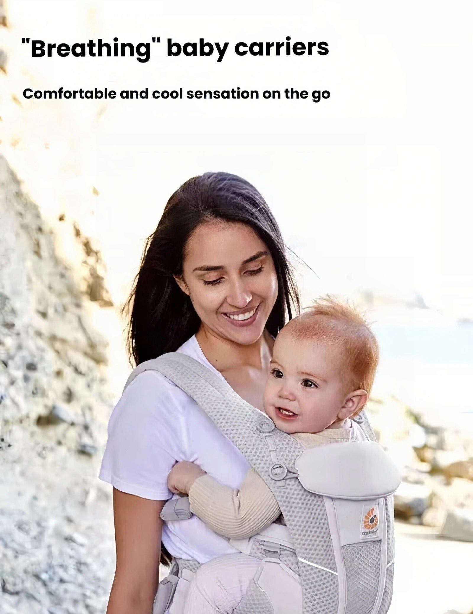 Mother carrying baby in Ergobaby Omni Classic Mesh Carrier at beach—lightweight, breathable mesh fabric provides cool, comfortable sensation during outdoor activities.