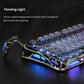 Close-up side view of the GravaStar Mercury K1 Lite gaming keyboard highlighting its three-sided flowing LED lighting. The vibrant blue and purple glow from the front, sides, and under-chassis illuminates the desk, offering five customizable lighting modes for immersive gaming setups.