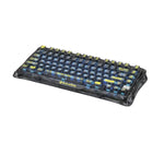 Top-down view of the GravaStar Mercury K1 Lite keyboard with transparent keycaps revealing internal components and blue backlighting. The clean, minimalist layout highlights the compact 75% form factor and ergonomic design, ideal for both typing and gaming.