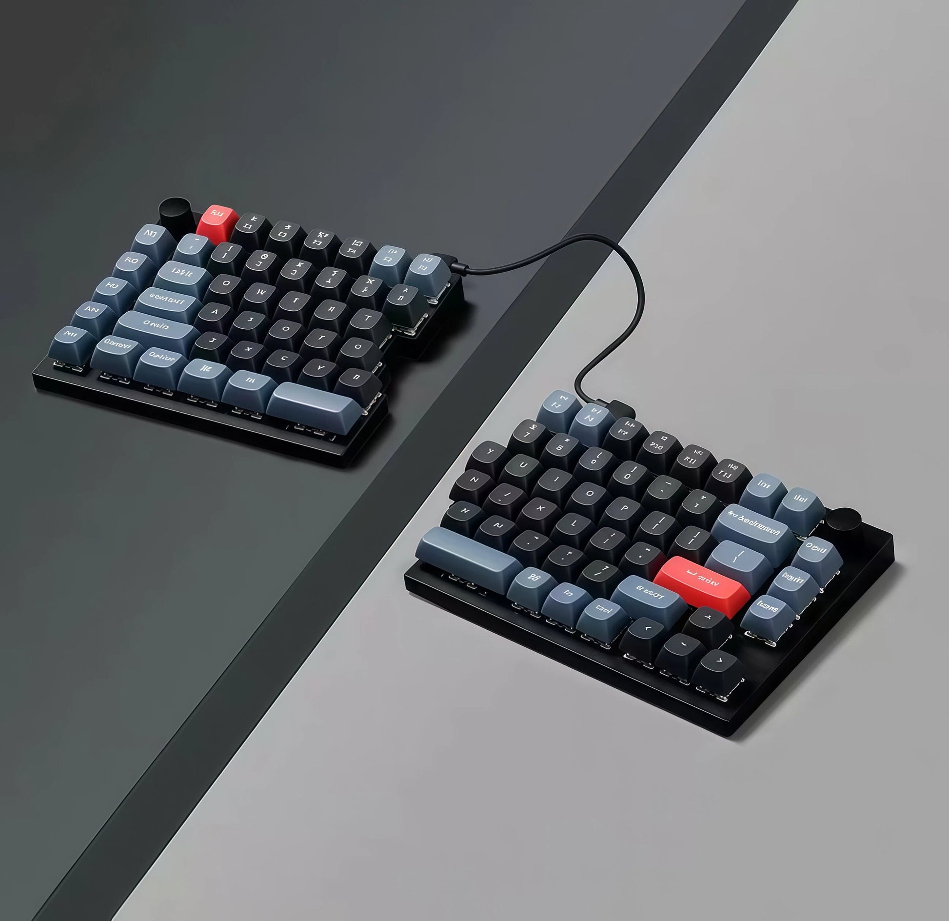 Keychron Q11 split mechanical keyboard with ergonomic layout placed on a modern desk setup, showcasing minimalist black and blue keycap design with red accent keys and dual cable connection.