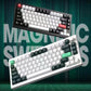 Side-by-side display of Keychron Q1 HE mechanical keyboards in white and black finishes, showcasing dual-color options with red ESC and Enter keys, magnetic switches, and CNC aluminum build.