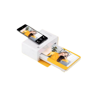 Kodak Docket Plus printer in action with smartphone inserted into top slot. A 4x6” photo is being printed directly from the phone, showcasing seamless integration and instant output.
