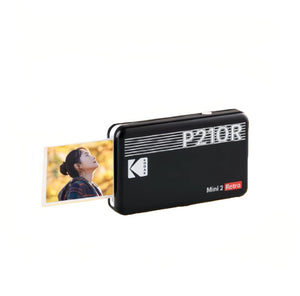 Kodak Mini 2 Retro P210R instant digital printer in black, printing a 2x3-inch photo. Features sleek retro design with silver grille and "P210R" branding. Ideal for instant photo printing from smartphone.