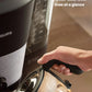 A close-up of the Philips HD7900 coffee machine's 1.25 L water tank with clear level lines, and a hand pouring water into it
