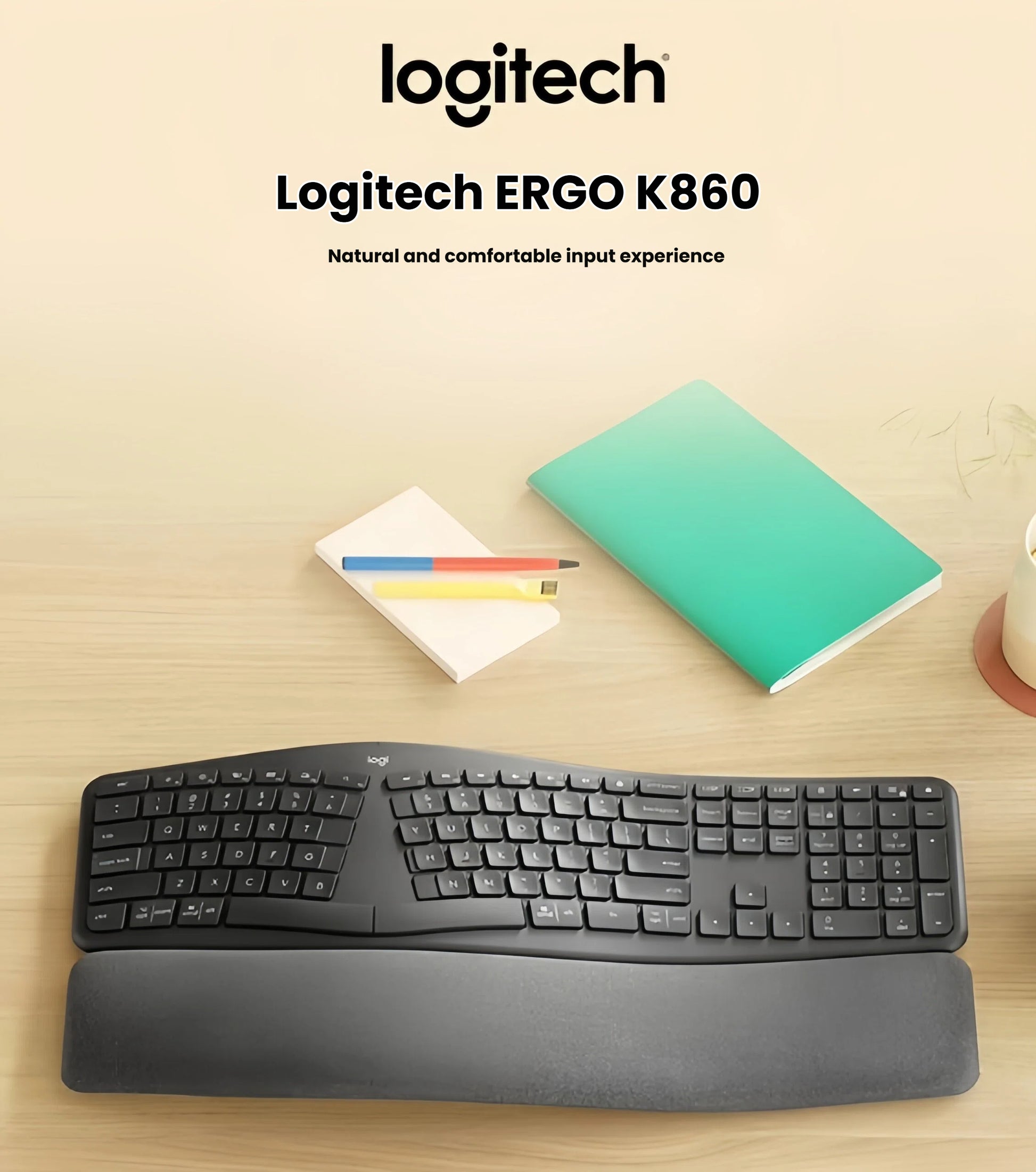  Lifestyle photo of the Logitech ERGO K860 split keyboard placed on a light wooden desk beside notebooks and colored pencils, emphasizing its sleek design and comfortable wrist support.