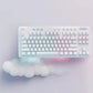 Stylized overhead photo of the white G715 keyboard and cloud wrist rest on a soft lavender background, emphasizing the dreamy gradient lighting and fashion-forward design for gamers and streamers.
