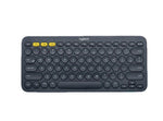 Top-down view of the dark gray Logitech K380 with yellow-accented Easy-Switch keys, emphasizing its professional look and multi-device Bluetooth connectivity.