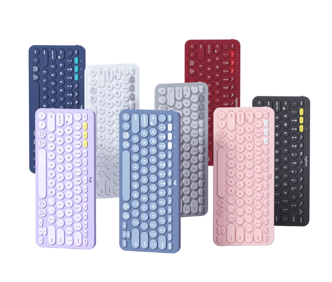 Group shot of the Logitech K380 wireless keyboard in seven vibrant colors—lavender, blue-gray, white, red, dark gray, pink, and navy—showcasing the compact, round-key design perfect for any setup.