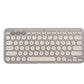 Neutral sand-colored Logitech K380 keyboard viewed from above, highlighting its understated tone and seamless compatibility with any modern device.