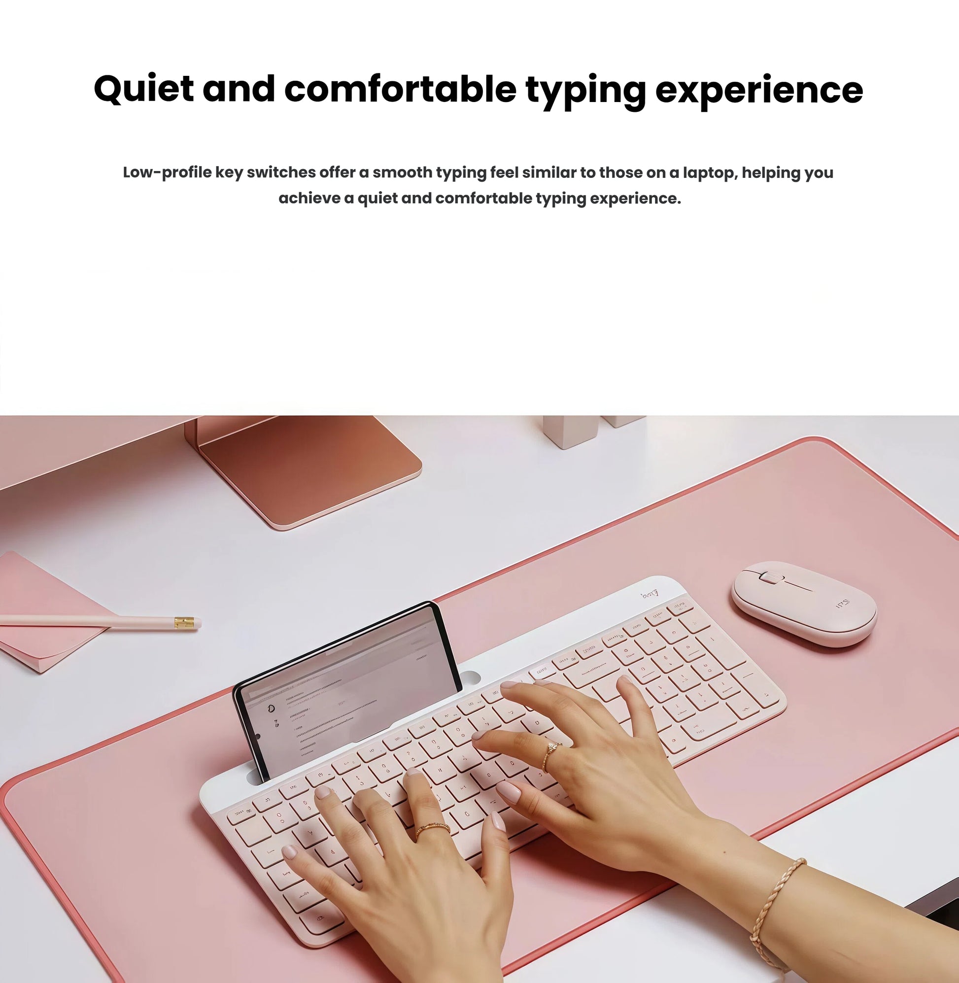 Close-up of hands typing on the rose K580 keyboard with a tablet in the built-in stand, showcasing low-profile scissor switches for a silent, laptop-like feel.