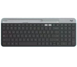 Overhead shot of the graphite Logitech K580 slim wireless keyboard, featuring a built-in phone/tablet cradle, full-size layout with numeric keypad, and dual-connectivity indicators.