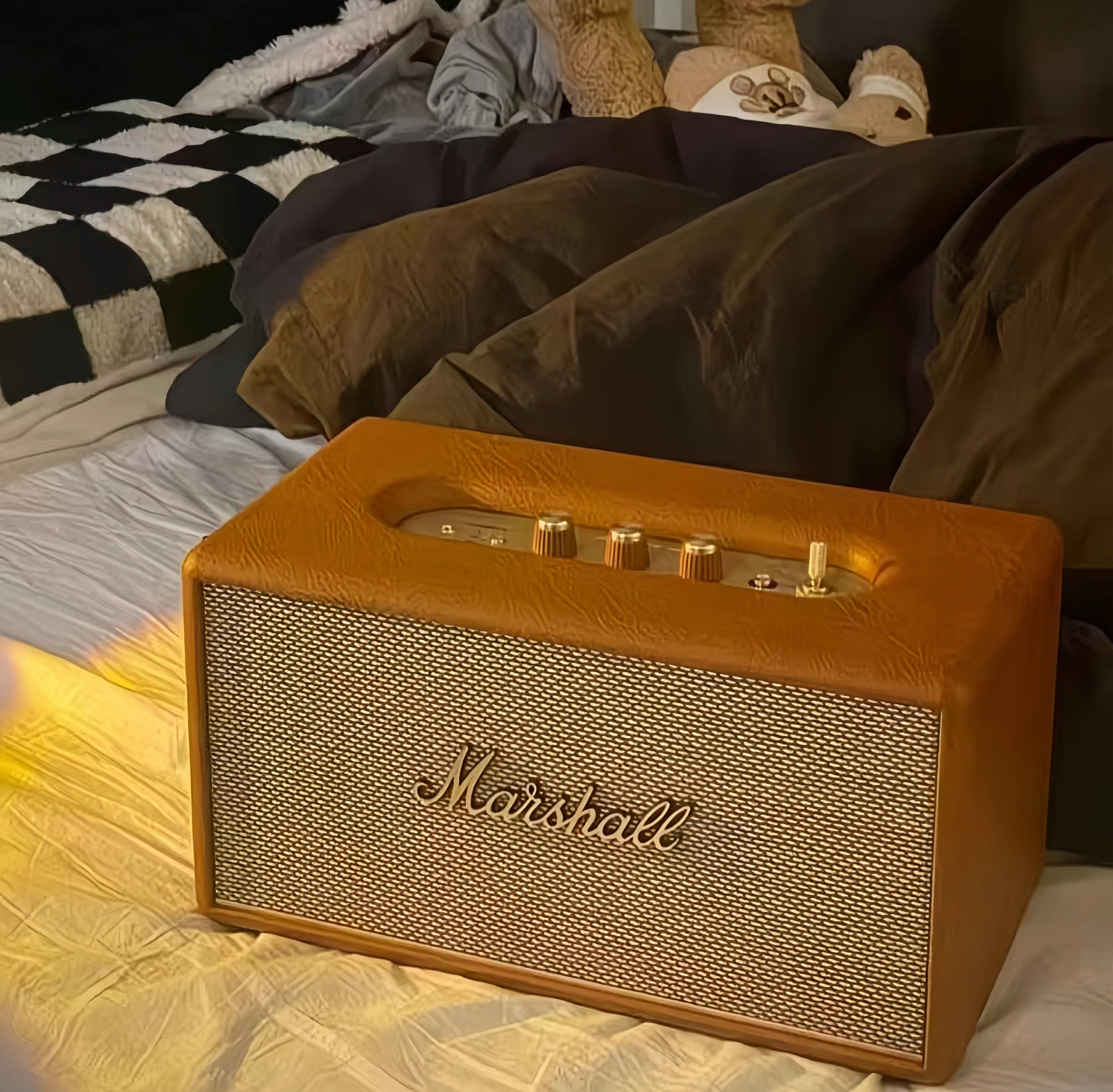 Bright lifestyle shot of the cream Marshall Stanmore III speaker placed next to a vase of pink and blue hydrangeas on a white console table, ideal for home styling inspiration.