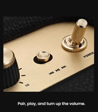 Macro shot of the Marshall Woburn III’s brass-finished control panel, featuring tactile power, volume, bass, and treble knobs for precise sound adjustment.