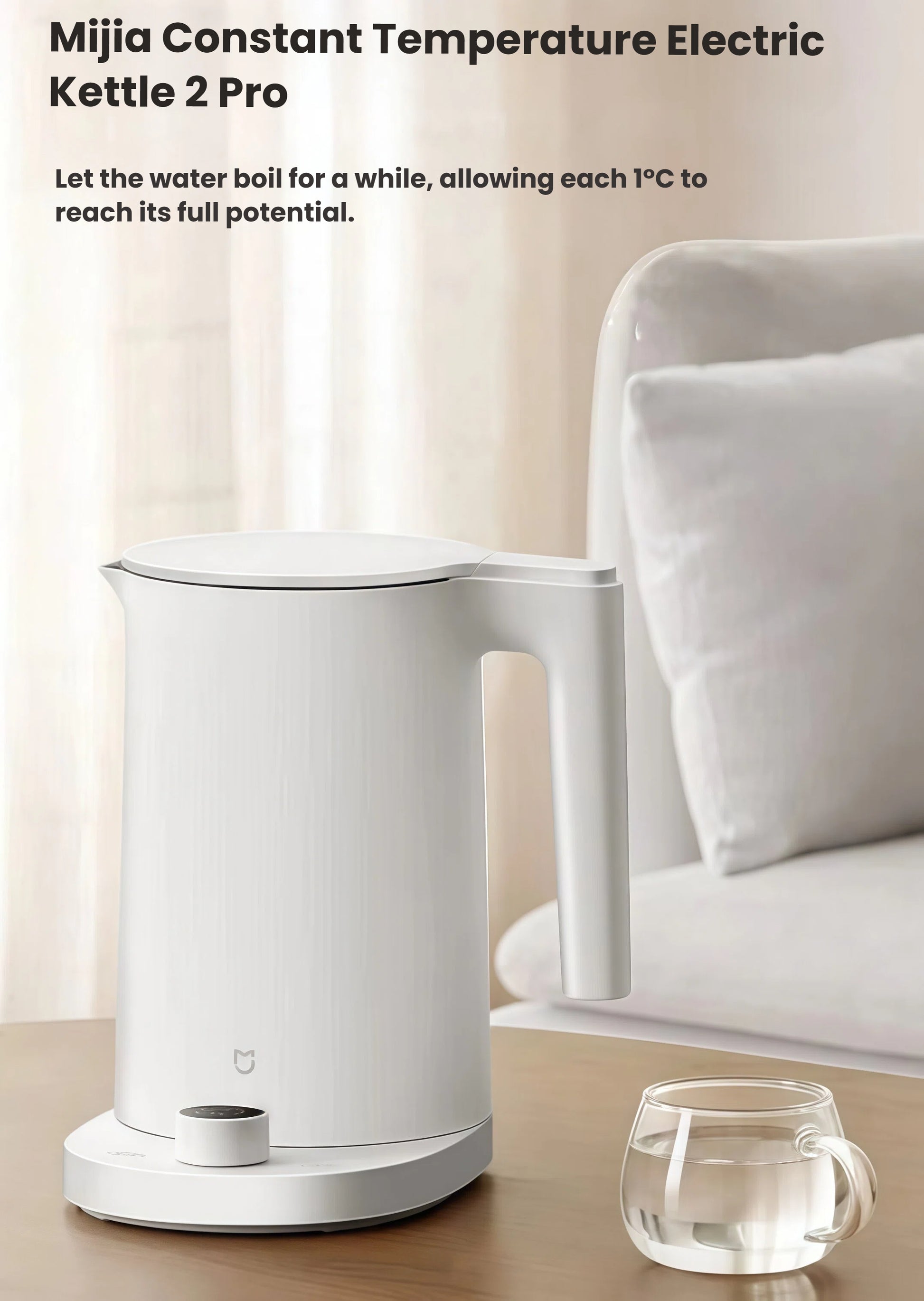 The white Mijia (Xiaomi) Smart Kettle 2 Pro sitting on a wooden table next to a clear glass cup, showcasing its elegant design for a modern home or office.