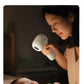 Mother gently drying her sleeping baby’s hair with SKULD baby hair dryer; soft LED light ring illuminates face without disturbing sleep or causing eye strain