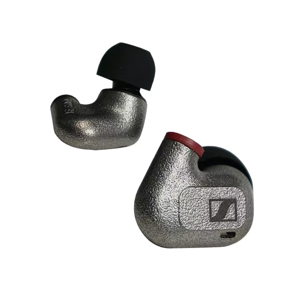 Close-up of Sennheiser IE 600 earphone housing showing textured metal finish, red accent ring, and Sennheiser logo — built for durability and premium audio performance.