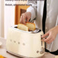 A person using the cream Smeg 50's Style 4-Slice Toaster, placing bread into the extra-wide slots, showcasing its luxury retro style and premium all-metal, piano lacquer finish.