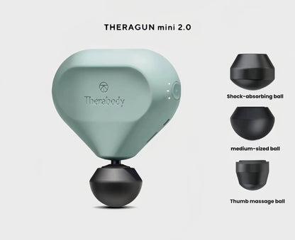 Sage green Theragun Mini 2.0 displayed with shock-absorbing, medium and thumb massage heads for targeted therapy.