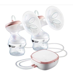 Tommee Tippee double electric breast pump featuring two bottles with measurement lines, dual breast shields, flexible tubing, and compact motor unit with pink accents. Designed for simultaneous pumping.