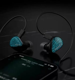 Topping ArpegEar Hane in-ear monitors placed beside a smartphone on a reflective surface, demonstrating premium build quality and compatibility with mobile devices for high-resolution audio playback.