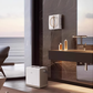 The ECOVACS Winbot W2 Pro is shown cleaning a large marble wall in a luxurious, modern bathroom with an ocean view, highlighting its versatility for cleaning various smooth surfaces beyond just windows.