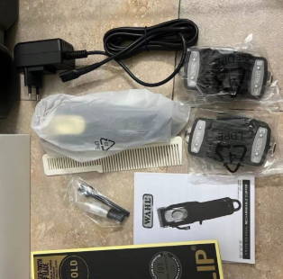 Contents of the Wahl Hair Clipper box laid out, including the clipper, combs, charger, and cleaning brush.