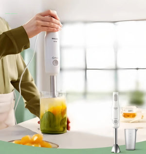 Mother using Philips Avent handheld blender to make smooth baby food from steamed vegetables like pumpkin and zucchini—safe, fast, and mess-free.