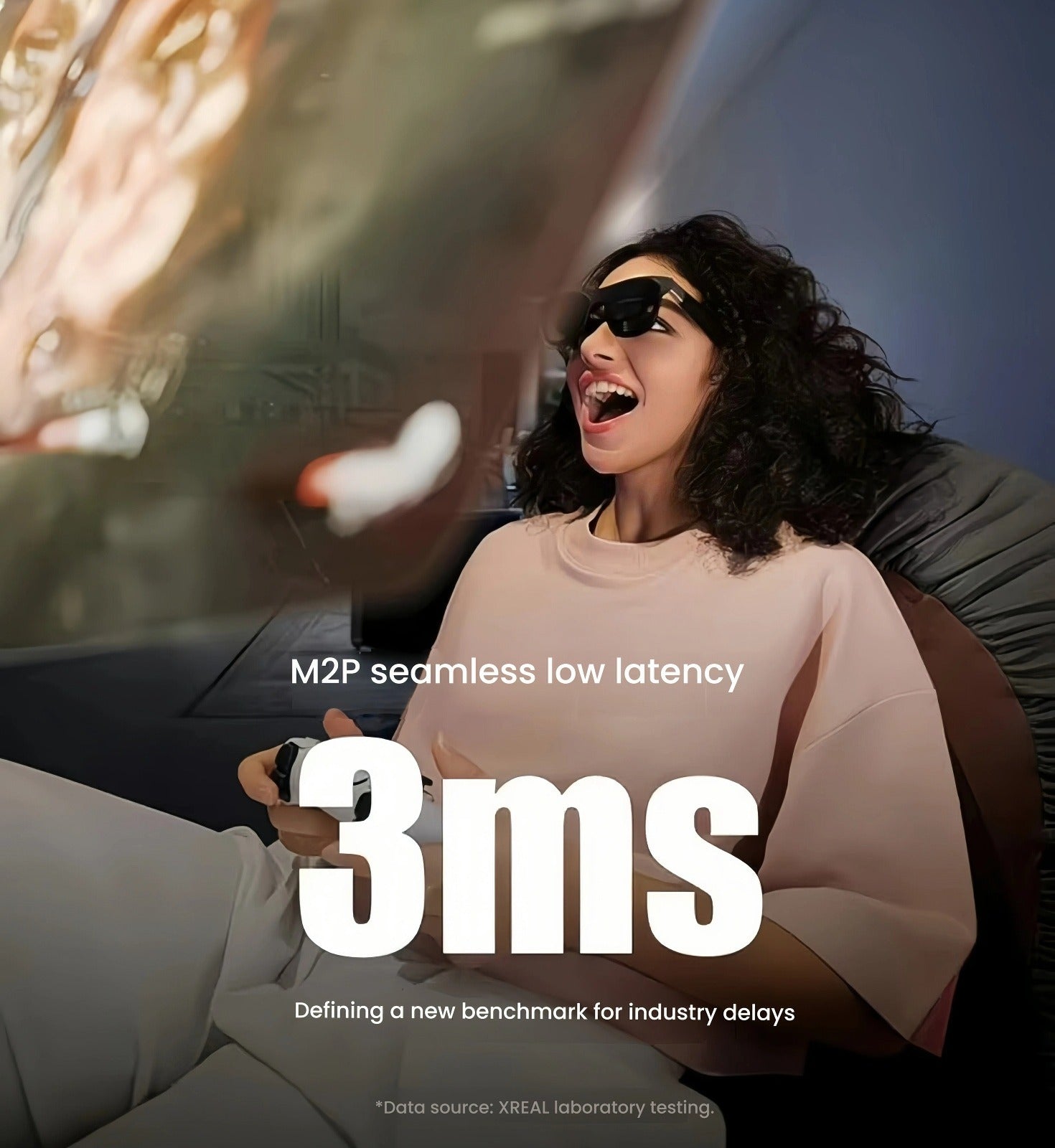 Woman gaming on couch with XREAL One AR glasses, highlighting 3 ms M2P latency and smooth 120 Hz refresh.