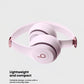 Pink Beats Solo 4 wireless on-ear headphones folded to showcase their lightweight, compact, and portable design, ideal for travel.