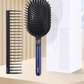 Image of a hair care set featuring a wide paddle brush with a curved design and pink handle, alongside a black wide-tooth comb. The brush has a flexible, ventilated structure with rounded bristles for gentle detangling, while the comb, labeled with the 'Dyson' logo, is designed for precise styling and easy detangling of wet or dry hair.