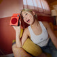 Orange CMF Speaker M being held by its integrated handle