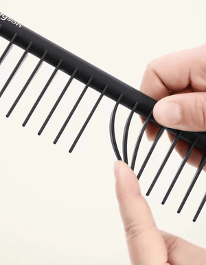 Image of a hair care set featuring a wide paddle brush with a curved design and pink handle, alongside a black wide-tooth comb. The brush has a flexible, ventilated structure with rounded bristles for gentle detangling, while the comb, labeled with the 'Dyson' logo, is designed for precise styling and easy detangling of wet or dry hair.