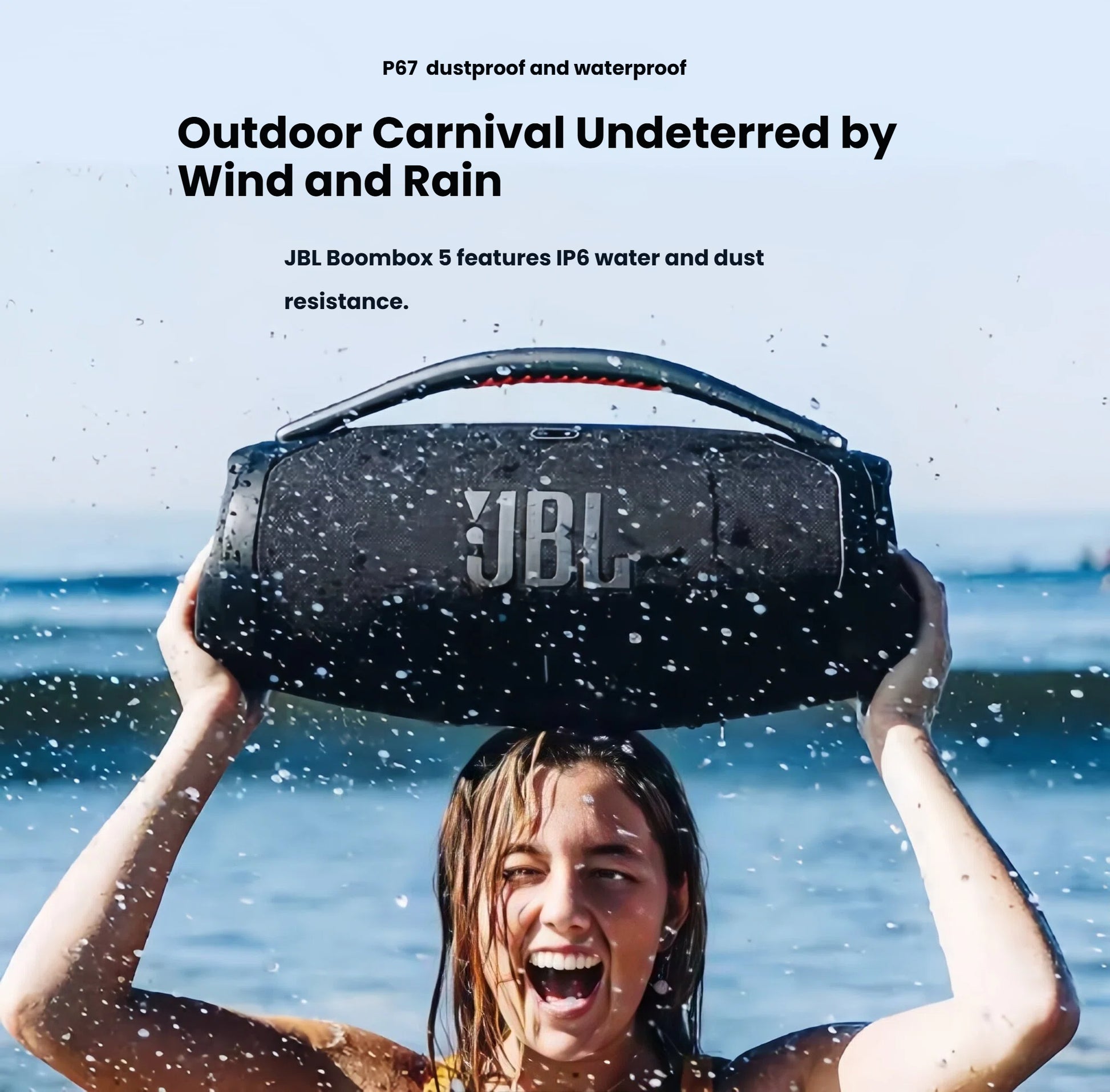 A woman holding the JBL Boombox 3 speaker at the beach, demonstrating its IP67 waterproof and dustproof rating for outdoor use without worry.