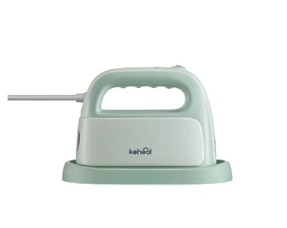 The Keheal portable handheld garment steamer in a light mint green color, shown from the side while resting on its protective heat-resistant base.