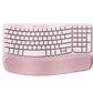 Top-down view of the rose pink Logitech Wave Keys wireless keyboard, highlighting the soft fabric wrist rest and unique wave curvature.