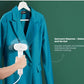 Action shot of the Midea garment steamer being used to quickly and effectively smooth out wrinkles from a hanging blue jacket before heading out.
